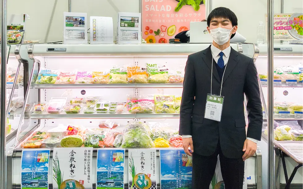 クラカブース前に立つ営業担当伊藤