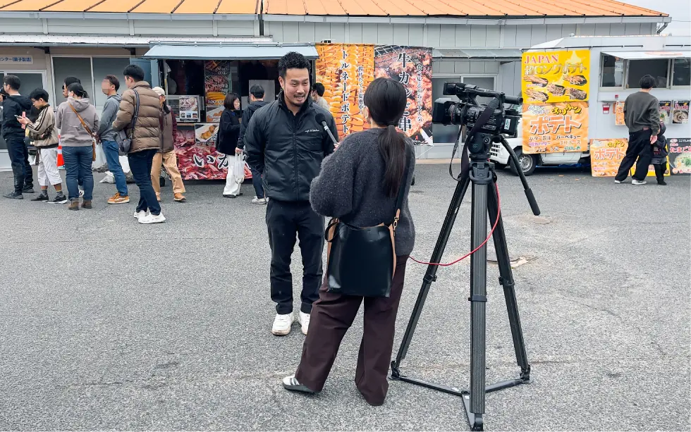 地元ケーブルテレビの取材に応じる主催者の福井さん